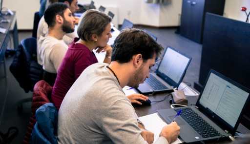 Studenti in aula seduti di fronte a un computer