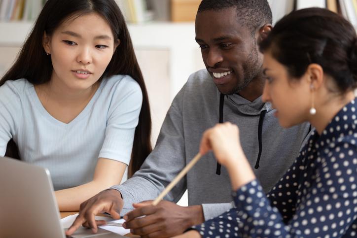 Studenti di varie nazionalità che guardano insieme un computer