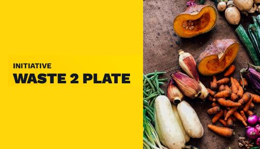 Programma Waste 2 Plate Titolo dell'avviso su sfondo colorato, sullo sfondo alcuni ortaggi su un tavolo di legno