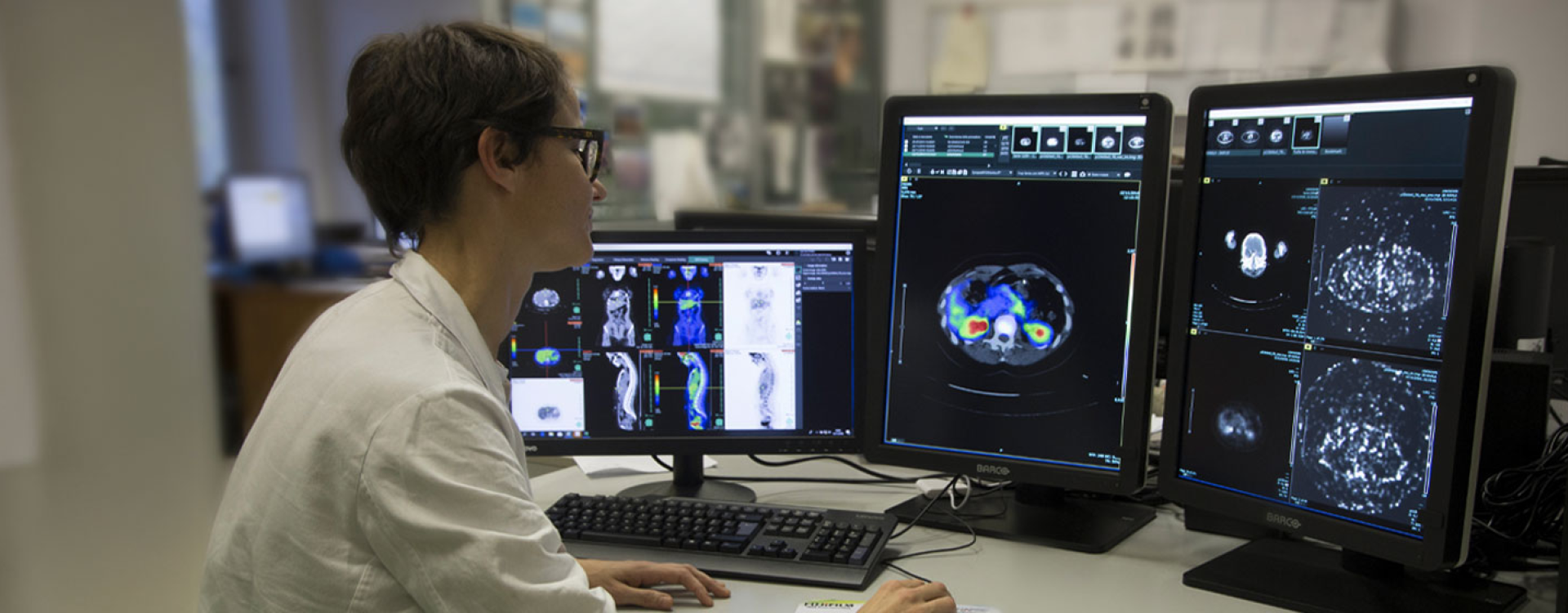 Una ricercatrice osserva delle analisi mediche al PC