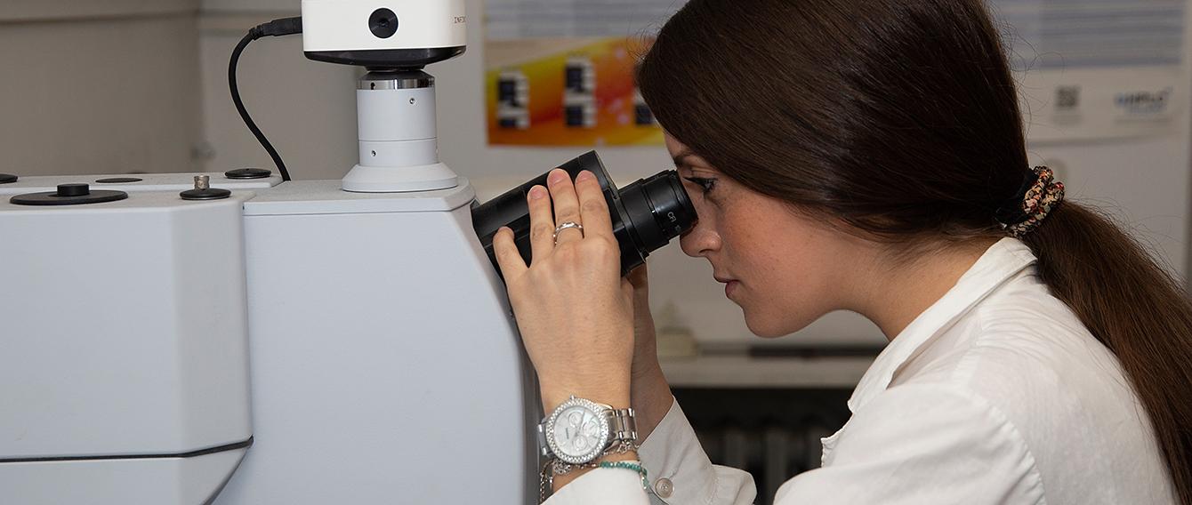 Ricercatrice che utilizza un microscopio