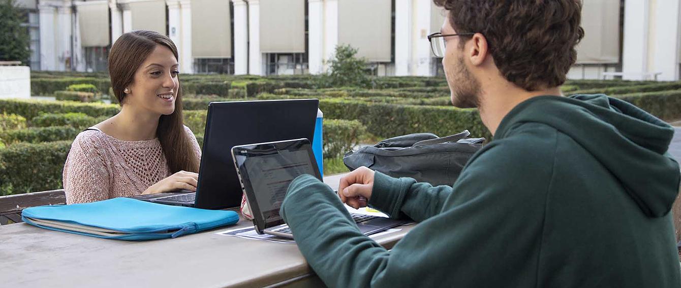 Due studenti impegnati nello studio su di un tavolo all'aperto