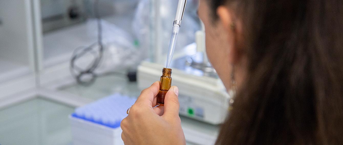 Mano femminile che utilizza una provetta