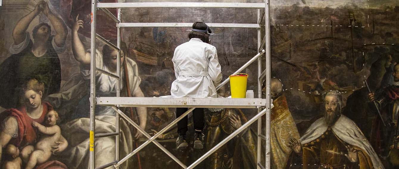 Ricercatrice intenta al restauro di un quadro