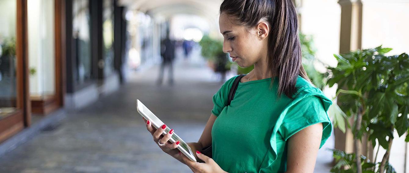 Studentessa che consulta un tablet sotto i portici di Savigliano