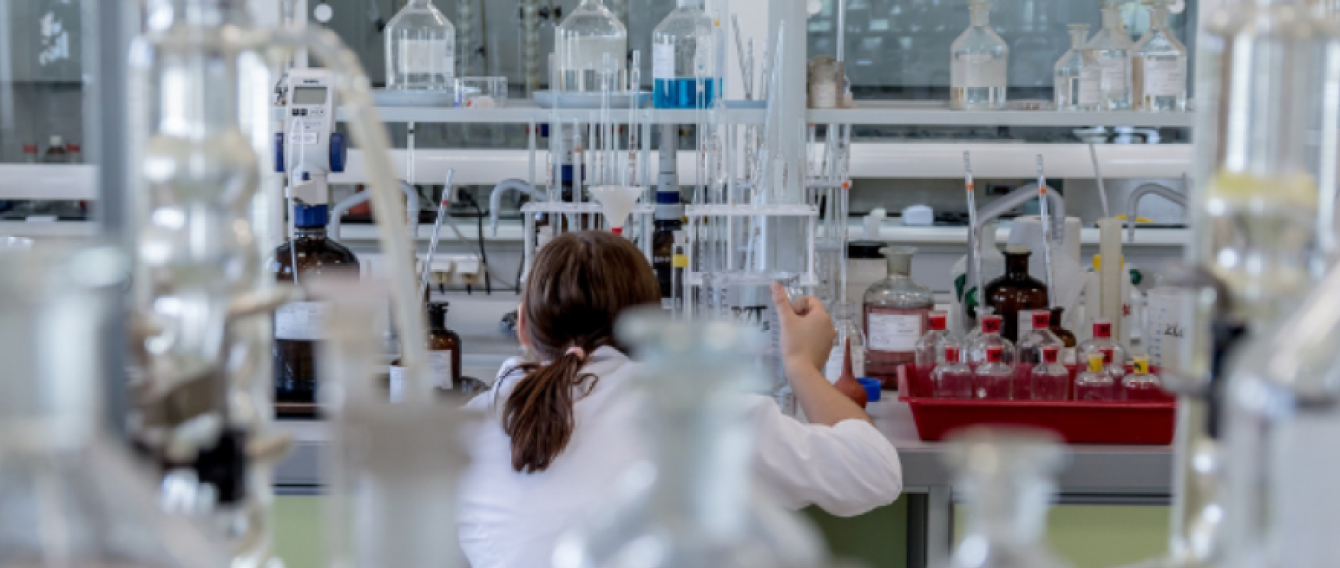 ricercatrice intenta a lavorare all'interno di un laboratorio chimico