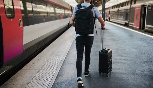 ragazzo di spalle che sta andando a prendere il treno