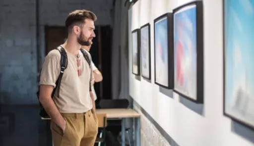 Ragazzo davanti a dei quadri appesi