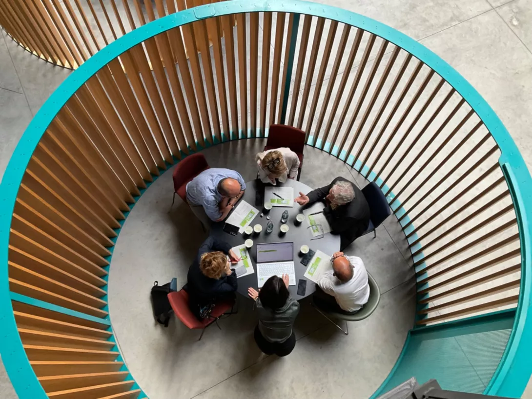 Foto di persone intorno a un tavolo che valutano i progetti