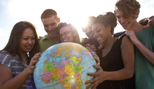 ragazze e ragazzi che sorreggono un mappamondo