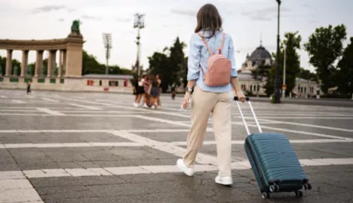 ragazza di spalle con un trolley