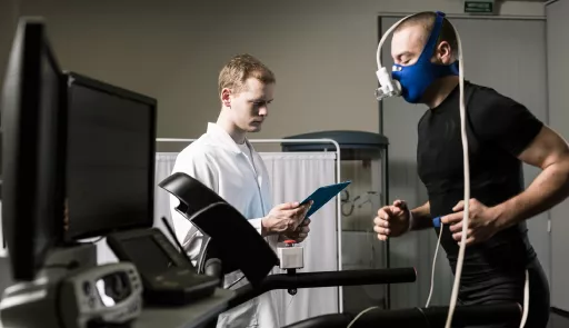 immagine di un paziente che corre su tapiroulant e medico che controlla