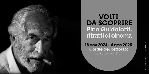Foto in bianco e nero del volto di un uomo con barba e capelli bianchi, in bocca una sigaretta
